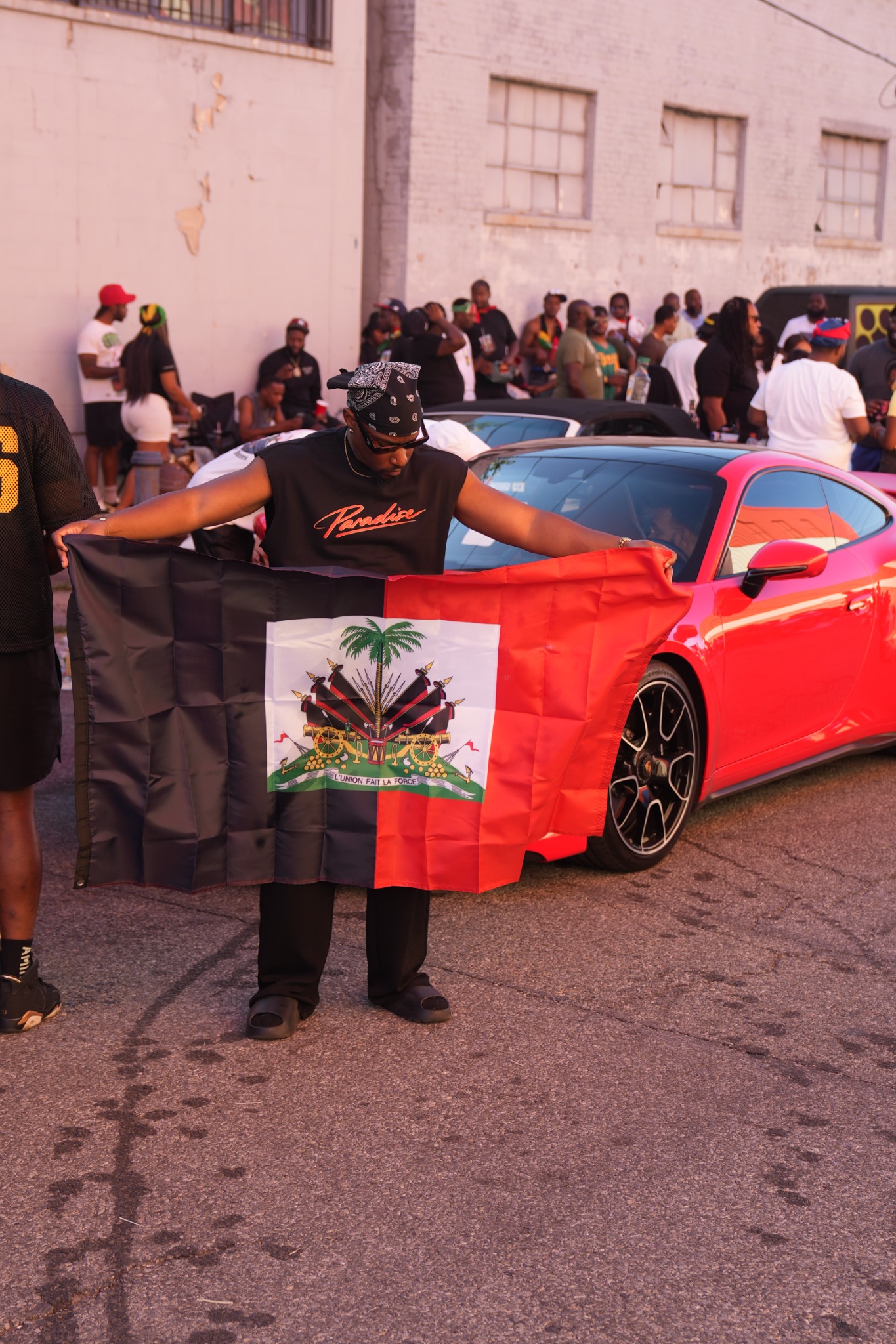 Guylaire looking down at the Haitian flag